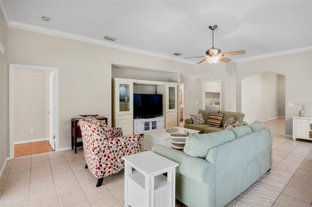 tiled living room with ceiling fan and ornamental molding