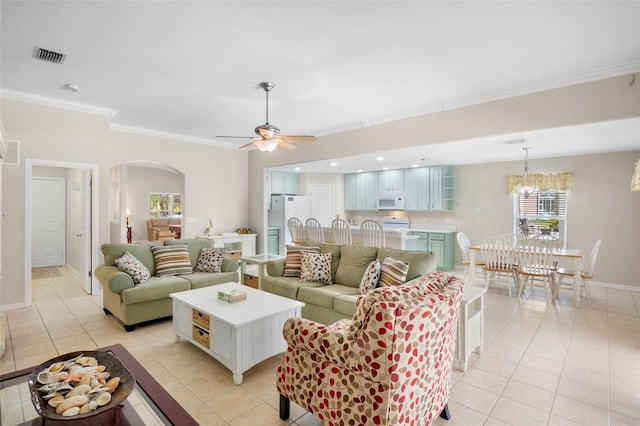 tiled living room with ornamental molding and ceiling fan with notable chandelier