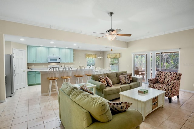 tiled living room with ornamental molding and ceiling fan