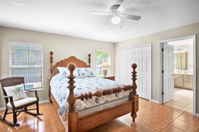 bedroom with ceiling fan, ensuite bath, a textured ceiling, and a closet