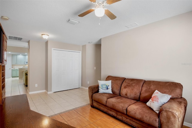 tiled living room featuring ceiling fan