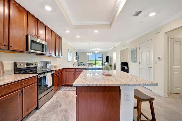 kitchen featuring appliances with stainless steel finishes, a breakfast bar, kitchen peninsula, crown molding, and light stone countertops