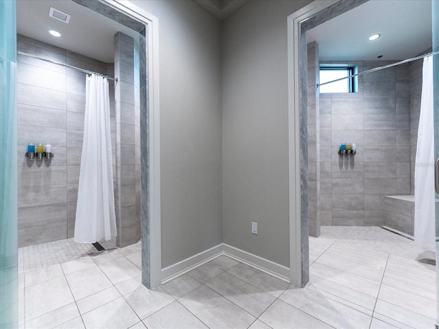 bathroom with curtained shower and tile patterned floors