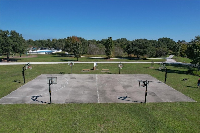 surrounding community featuring basketball court and a lawn