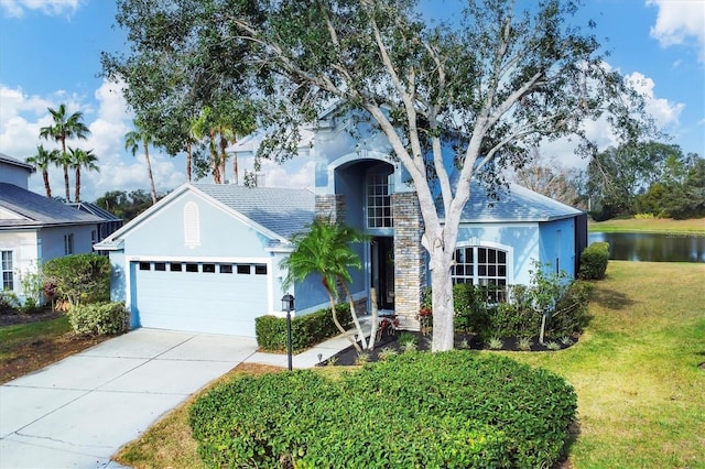 view of front of house featuring a front yard, a garage, and a water view