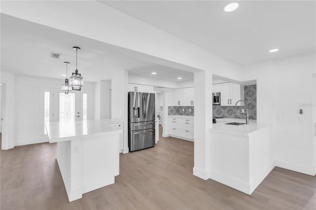 1950 Fairview Dr, Englewood, FL 34223 - kitchen with sink, appliances with stainless steel finishes, white cabinetry, and kitchen peninsula
