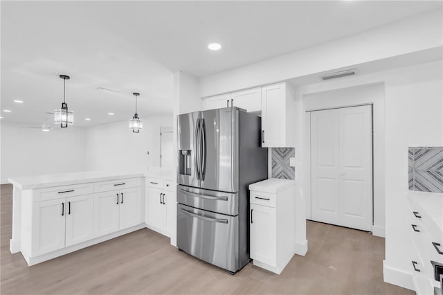 1950 Fairview Dr, Englewood, FL 34223 - kitchen featuring white cabinetry, kitchen peninsula, and stainless steel fridge with ice dispenser