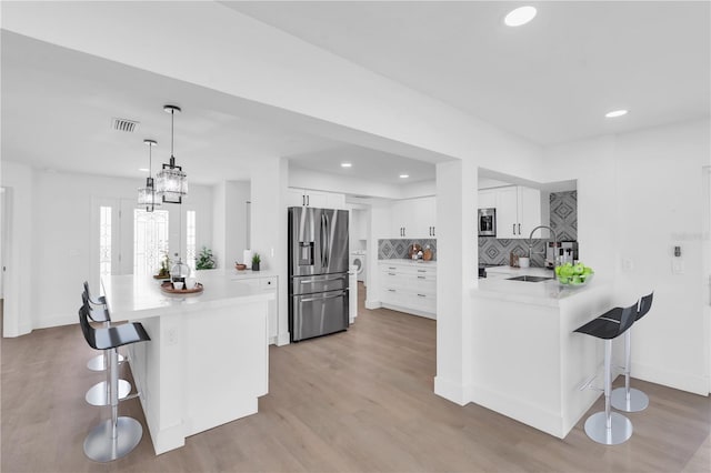 1950 Fairview Dr, Englewood, FL 34223 - kitchen featuring white cabinetry, sink, a kitchen bar, and stainless steel appliances