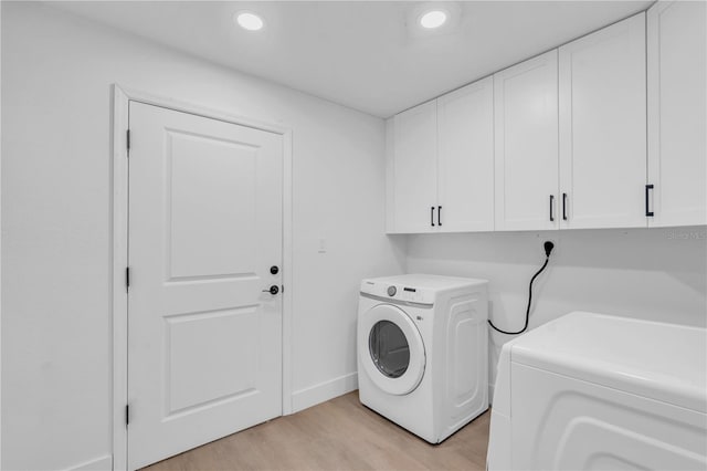 1950 Fairview Dr, Englewood, FL 34223 - laundry room with cabinets, light hardwood / wood-style floors, and washing machine and clothes dryer