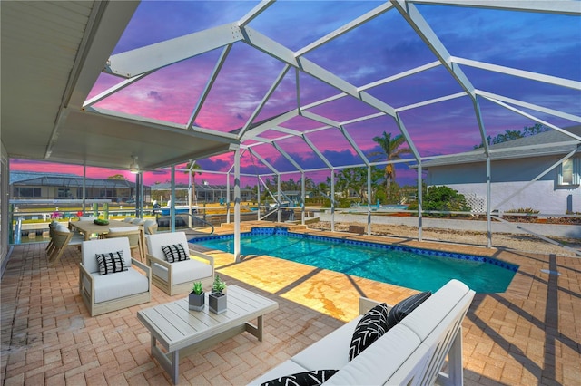 1950 Fairview Dr, Englewood, FL 34223 - pool at dusk with outdoor lounge area, a patio, and glass enclosure