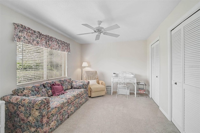 carpeted living room featuring a textured ceiling and ceiling fan