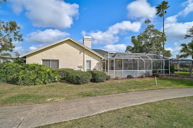 exterior space with glass enclosure and a lawn