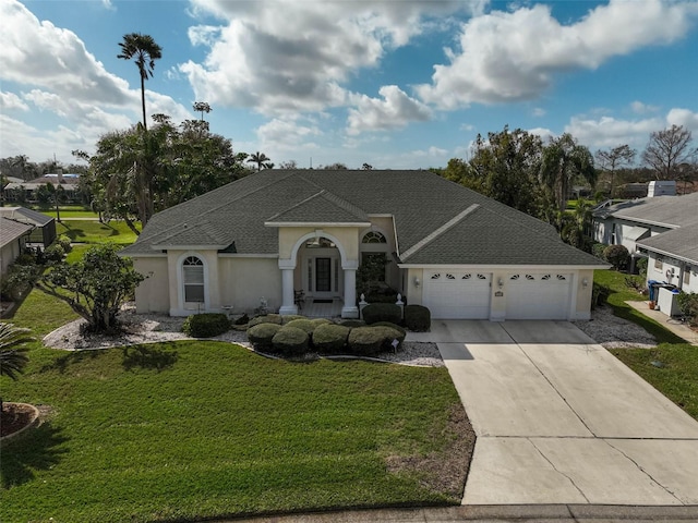 ranch-style home featuring a garage and a front lawn