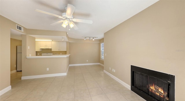 unfurnished living room featuring light tile patterned floors, ceiling fan, and rail lighting