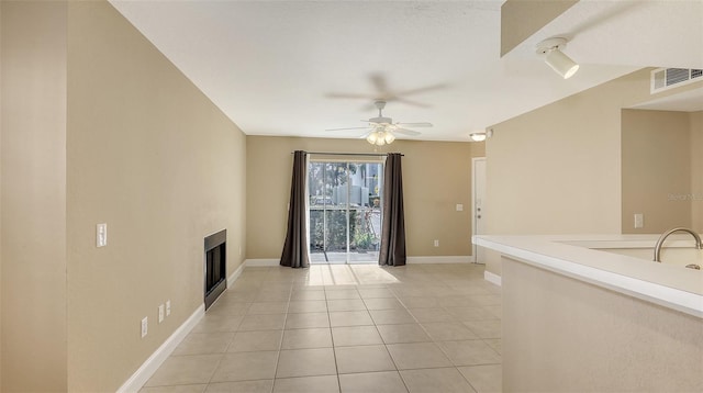 unfurnished living room featuring ceiling fan and light tile patterned floors