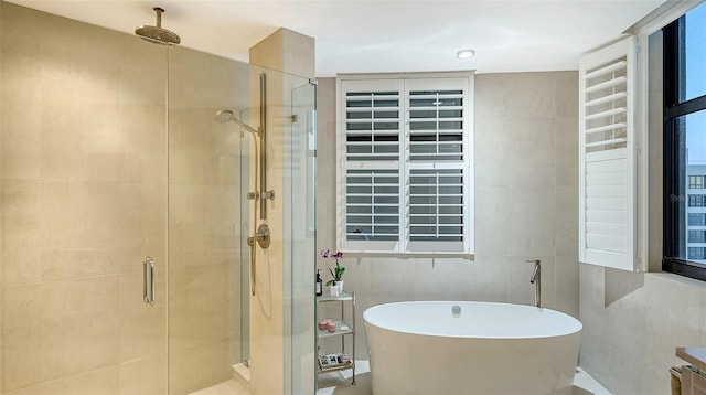 bathroom featuring independent shower and bath and tile walls