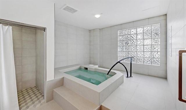 bathroom with a shower with curtain, tile patterned floors, and tile walls