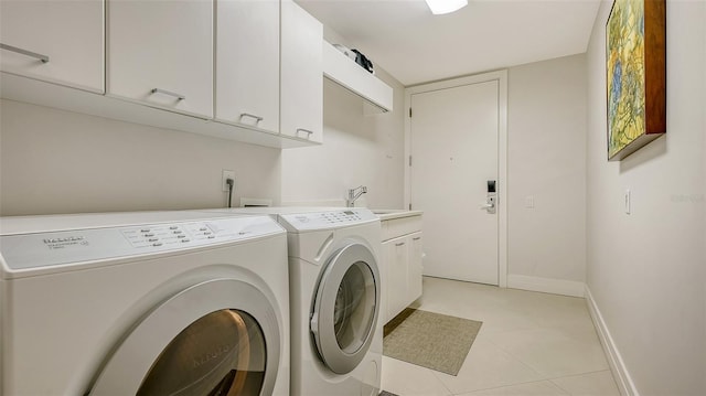 clothes washing area with cabinets, washing machine and dryer, sink, and light tile patterned flooring