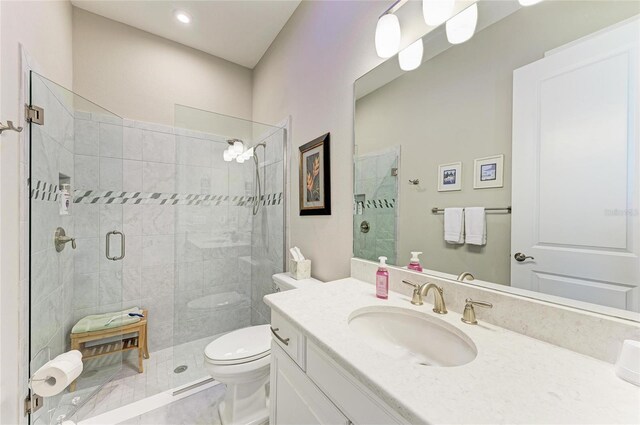 bathroom with a shower with door, vanity, and toilet