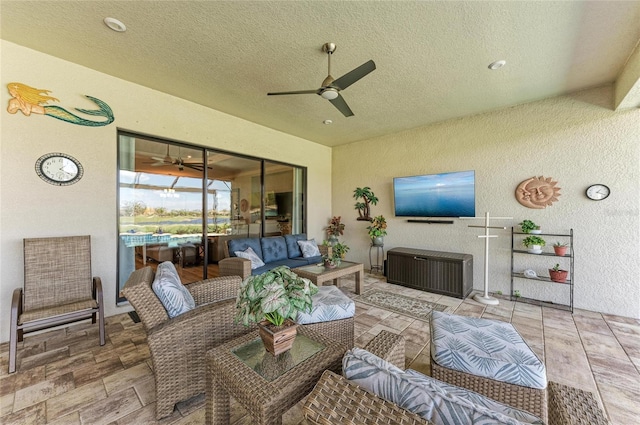 living room with a textured ceiling and ceiling fan