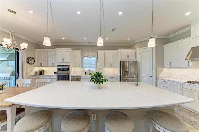 kitchen featuring a kitchen breakfast bar, white cabinetry, decorative backsplash, a spacious island, and stainless steel appliances