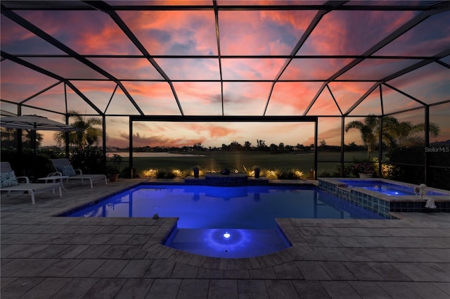 pool at dusk with a lanai, a pool with connected hot tub, and a patio area