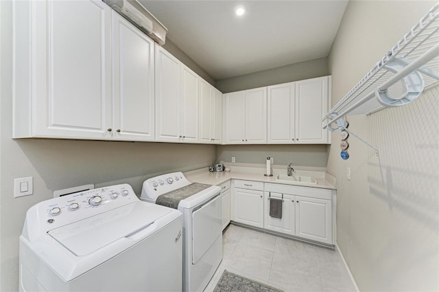 laundry room featuring a sink, cabinet space, light tile patterned flooring, baseboards, and washer and dryer