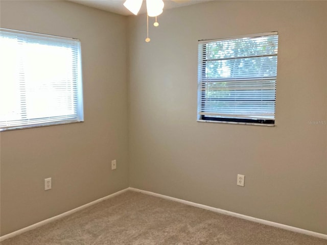 empty room featuring ceiling fan and carpet