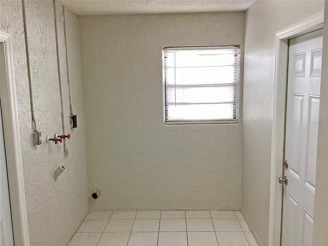 laundry room featuring light tile patterned floors and a textured ceiling