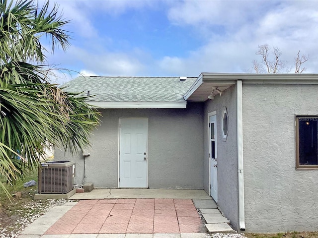 property entrance with central AC unit and a patio