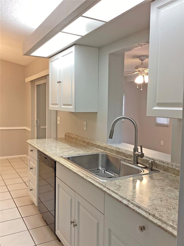 kitchen featuring white cabinetry, black dishwasher, sink, and light tile patterned floors