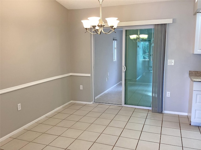 tiled empty room featuring a notable chandelier