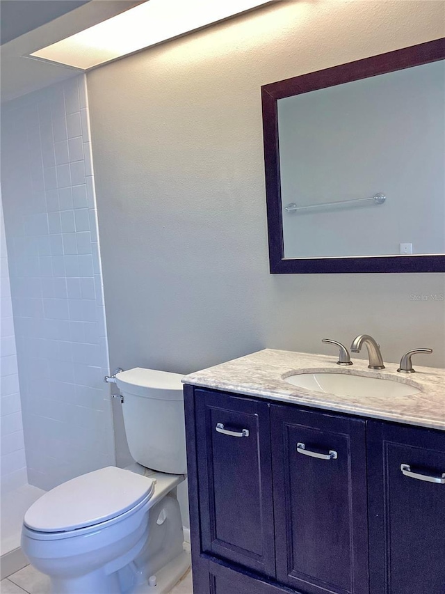 bathroom featuring vanity, toilet, tile patterned flooring, and a shower