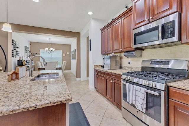 kitchen featuring pendant lighting, sink, decorative backsplash, and stainless steel appliances