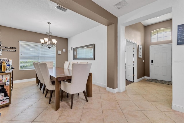 dining space with an inviting chandelier, light tile patterned floors, and a wealth of natural light