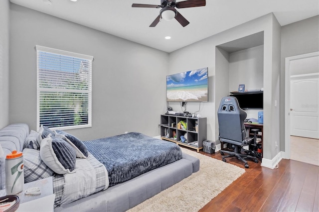 bedroom with dark hardwood / wood-style floors and ceiling fan