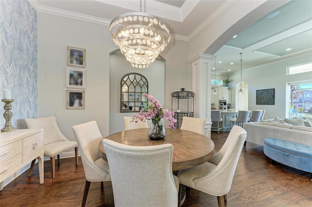 dining area featuring a notable chandelier, crown molding, dark hardwood / wood-style floors, and ornate columns