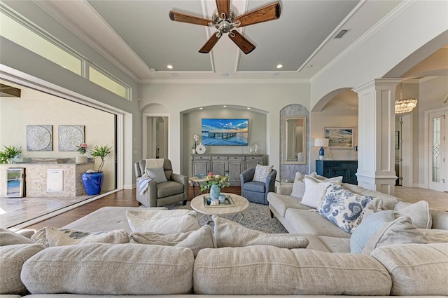 living room with crown molding, decorative columns, and a healthy amount of sunlight