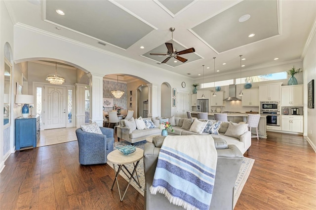 living room featuring ornate columns, coffered ceiling, dark hardwood / wood-style flooring, and a high ceiling