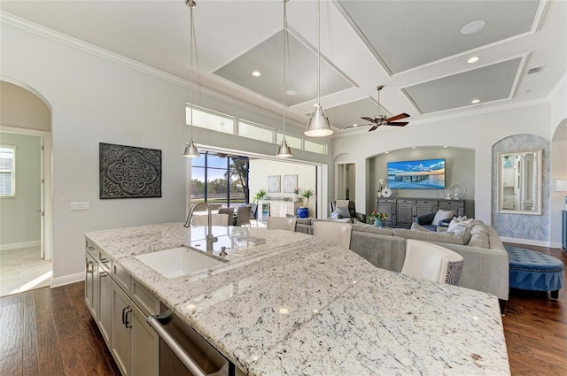 kitchen featuring dark wood-type flooring, coffered ceiling, sink, light stone counters, and hanging light fixtures