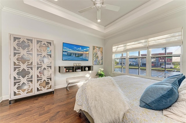 bedroom featuring crown molding, ceiling fan, dark hardwood / wood-style flooring, and a tray ceiling