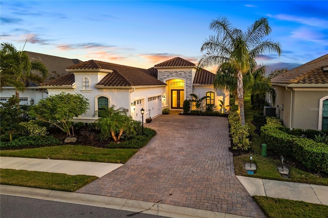 mediterranean / spanish-style home featuring a garage and central AC