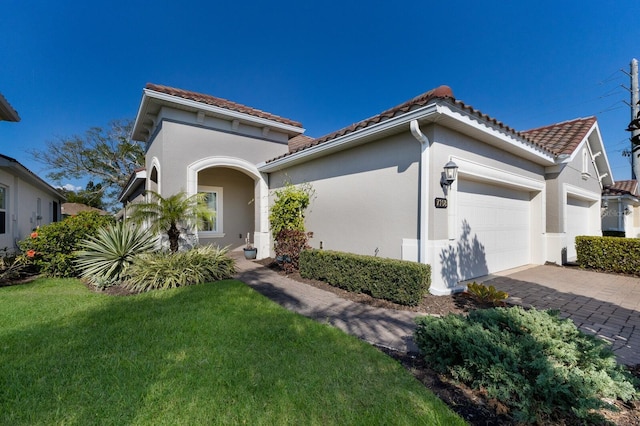 mediterranean / spanish house featuring a garage and a front yard