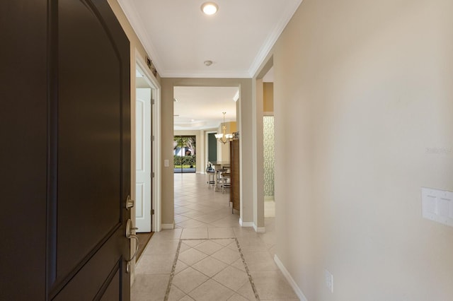 hall featuring ornamental molding, light tile patterned flooring, and a chandelier