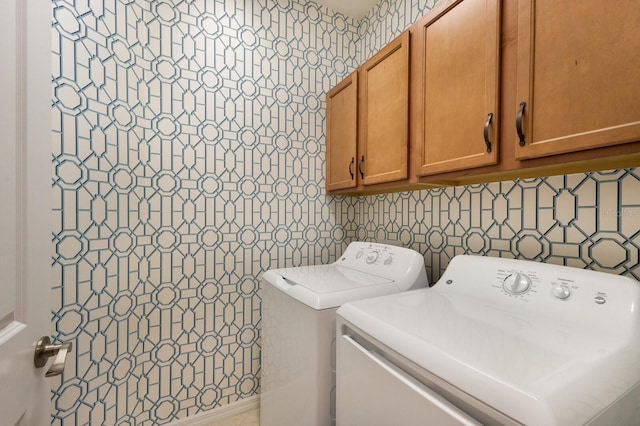 clothes washing area featuring cabinets and washing machine and clothes dryer