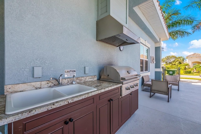 view of patio with an outdoor kitchen, sink, and grilling area