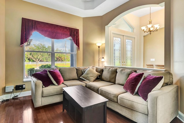 living room featuring a chandelier, dark hardwood / wood-style flooring, and french doors