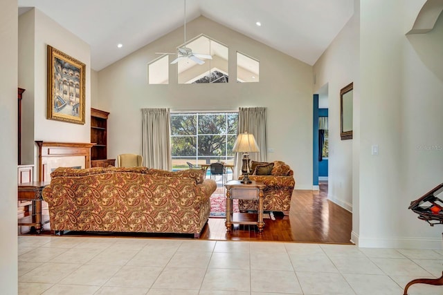 tiled living room featuring high vaulted ceiling and ceiling fan