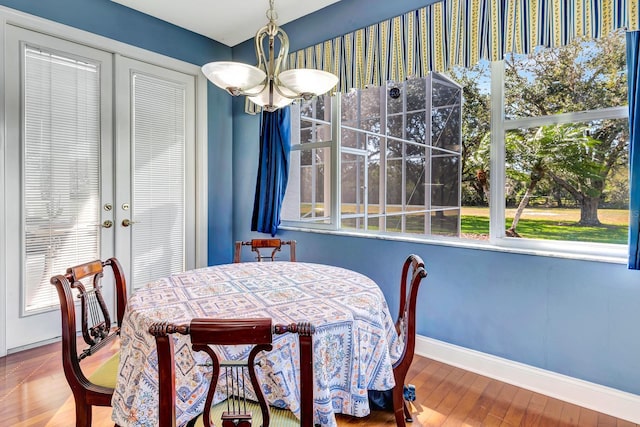 dining area featuring hardwood / wood-style flooring and a notable chandelier