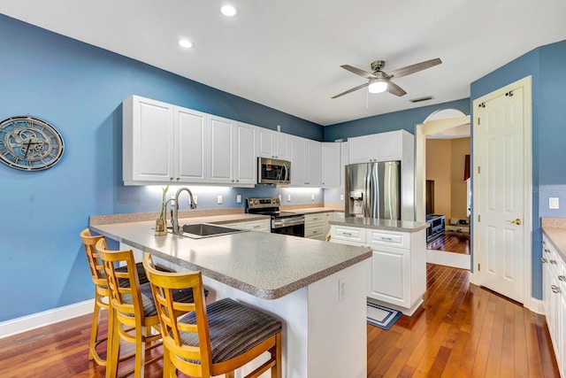 kitchen with white cabinetry, sink, a breakfast bar, and appliances with stainless steel finishes